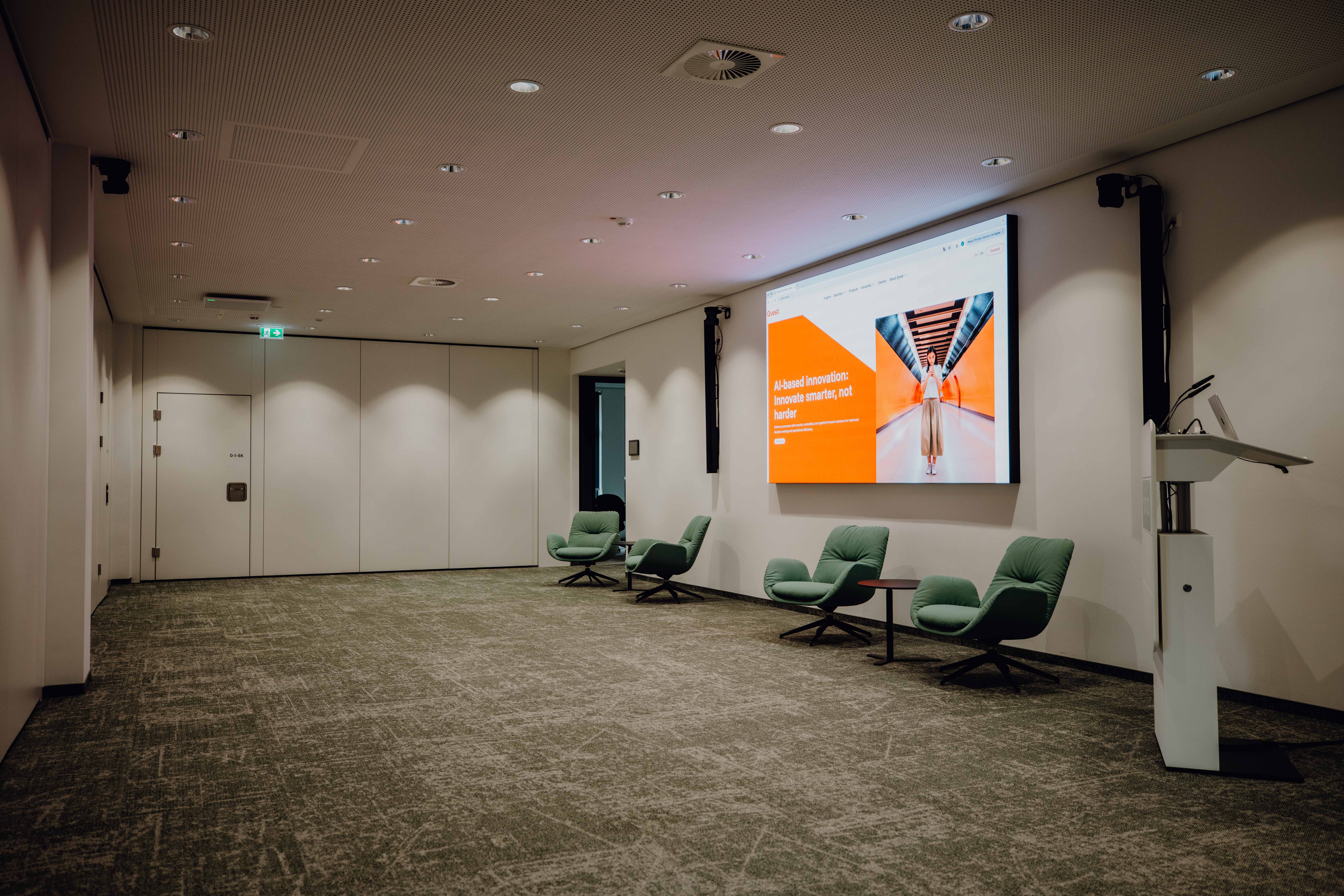 Leerer Konferenzraum mit Stühlen und Bildschirm.