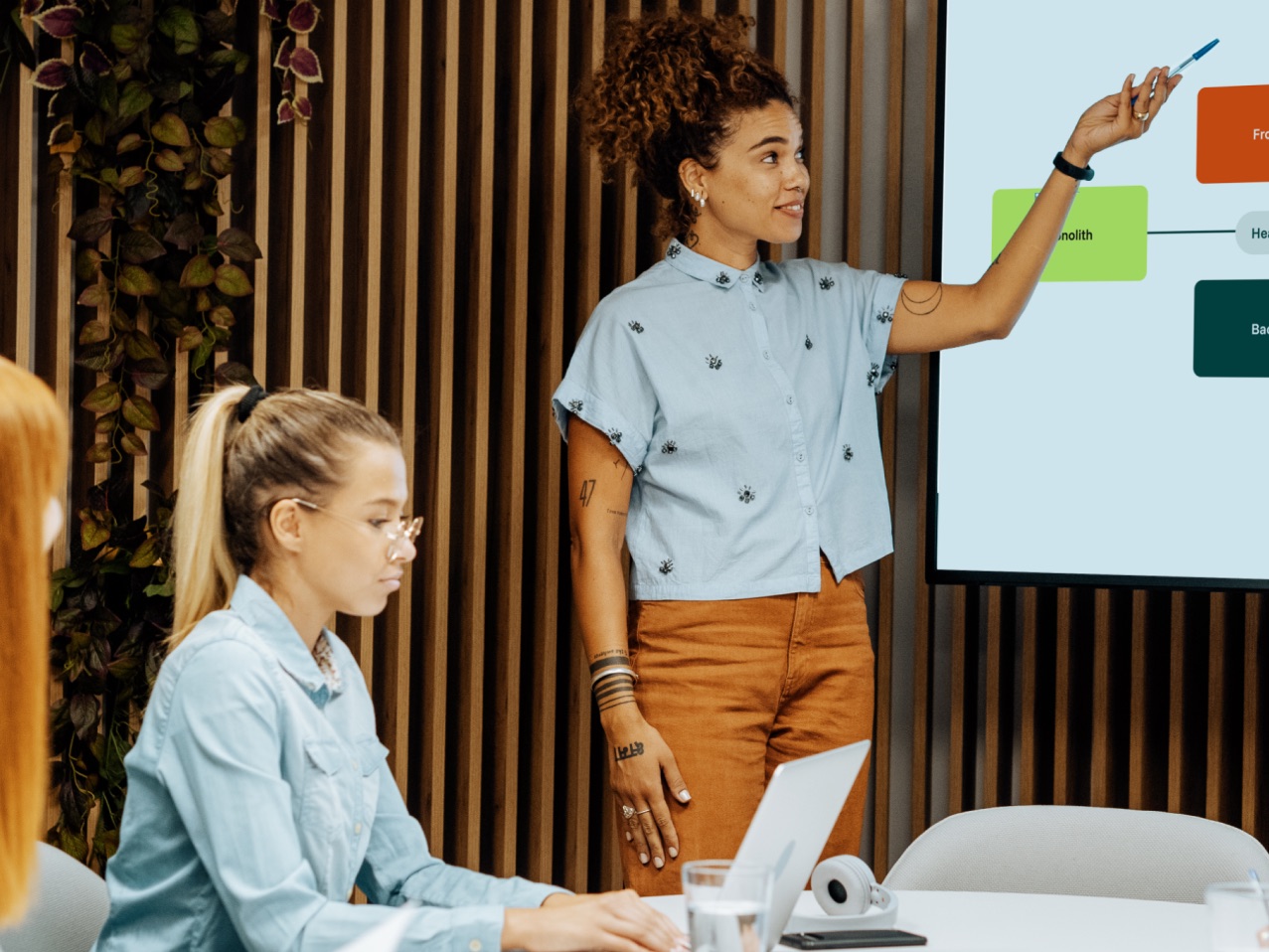 A workshop: someone explaining an architecture diagram on a screen to a seated group