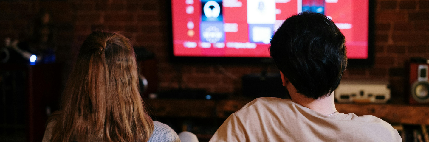 Zwei Personen, die einen Fernseher anschauen.