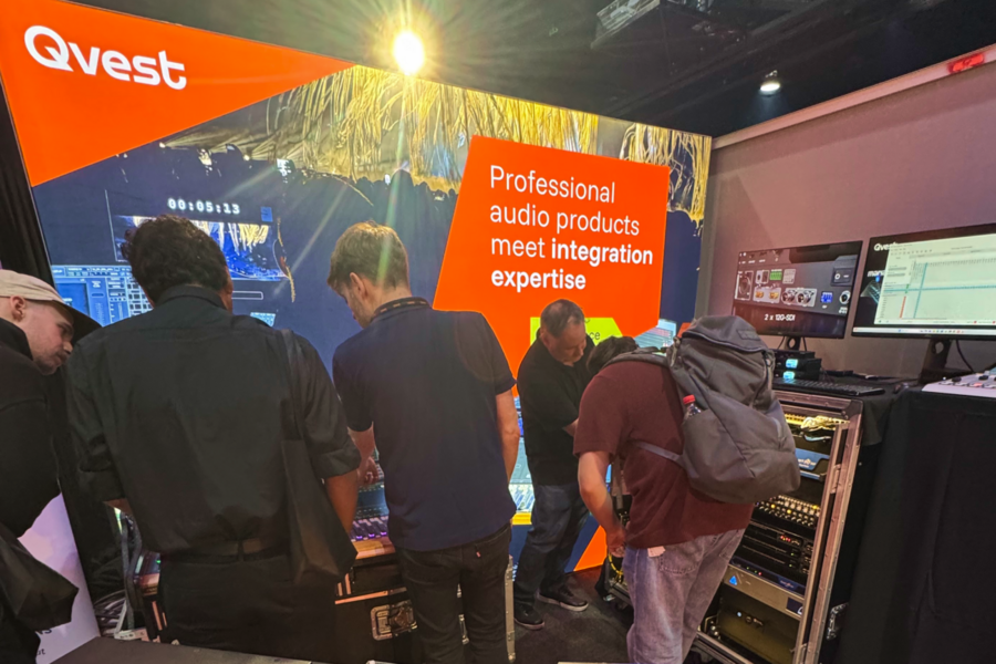 People interacting at a Qvest booth.
