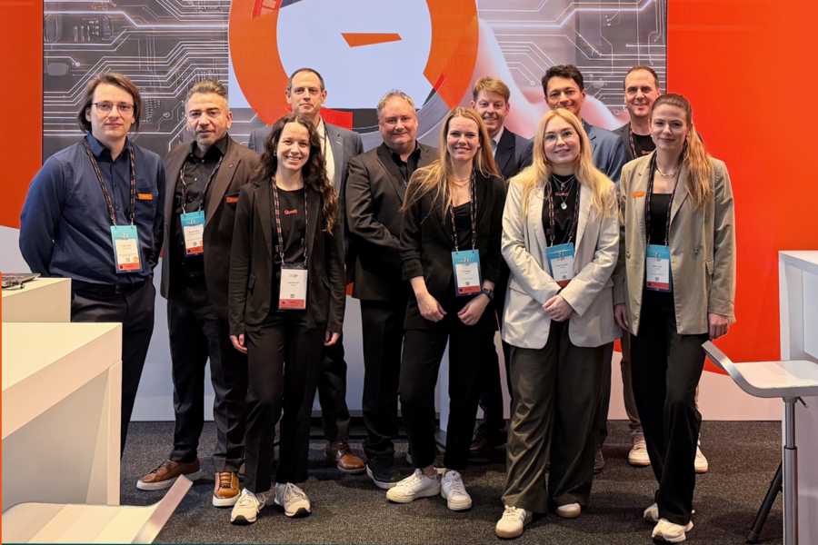 Trade show team at the Qvest booth with “Keep on AVolutionizing – Thank you for visiting”.