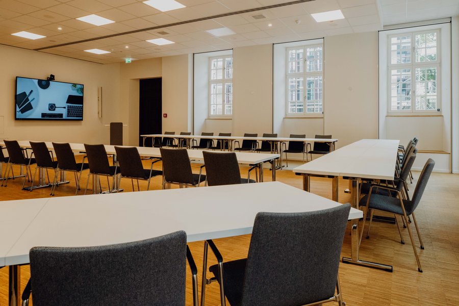 Empty conference room with rows of tables.