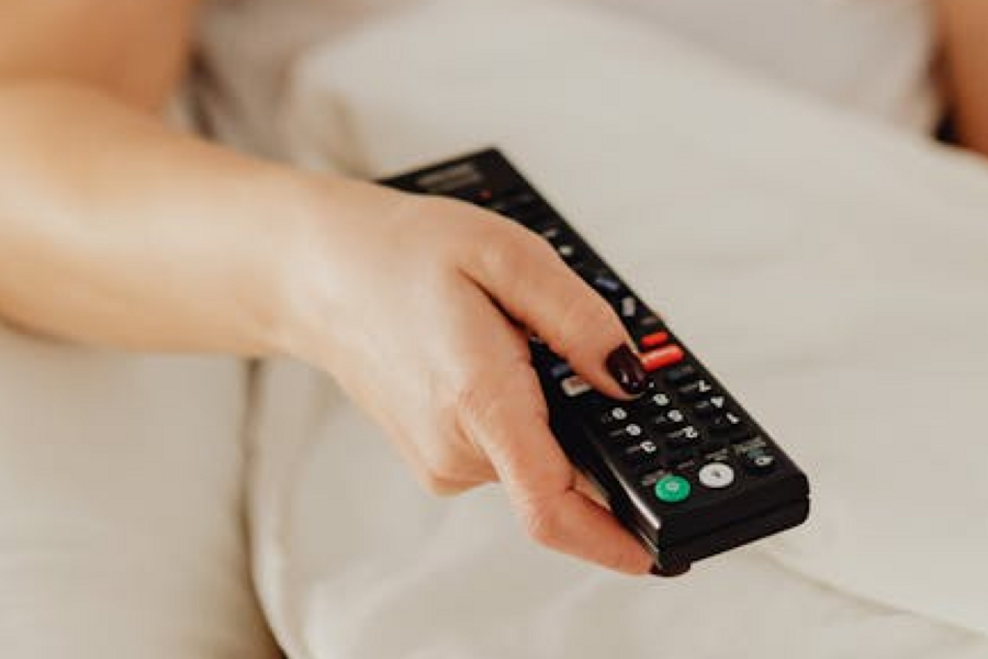 Hand holding a TV remote.