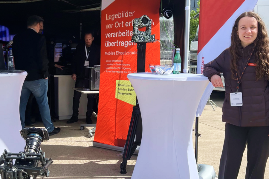 Person steht neben einem Ausstellungsstand.