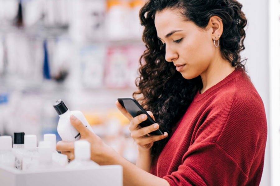 Woman scanning ingredients of beauty products.