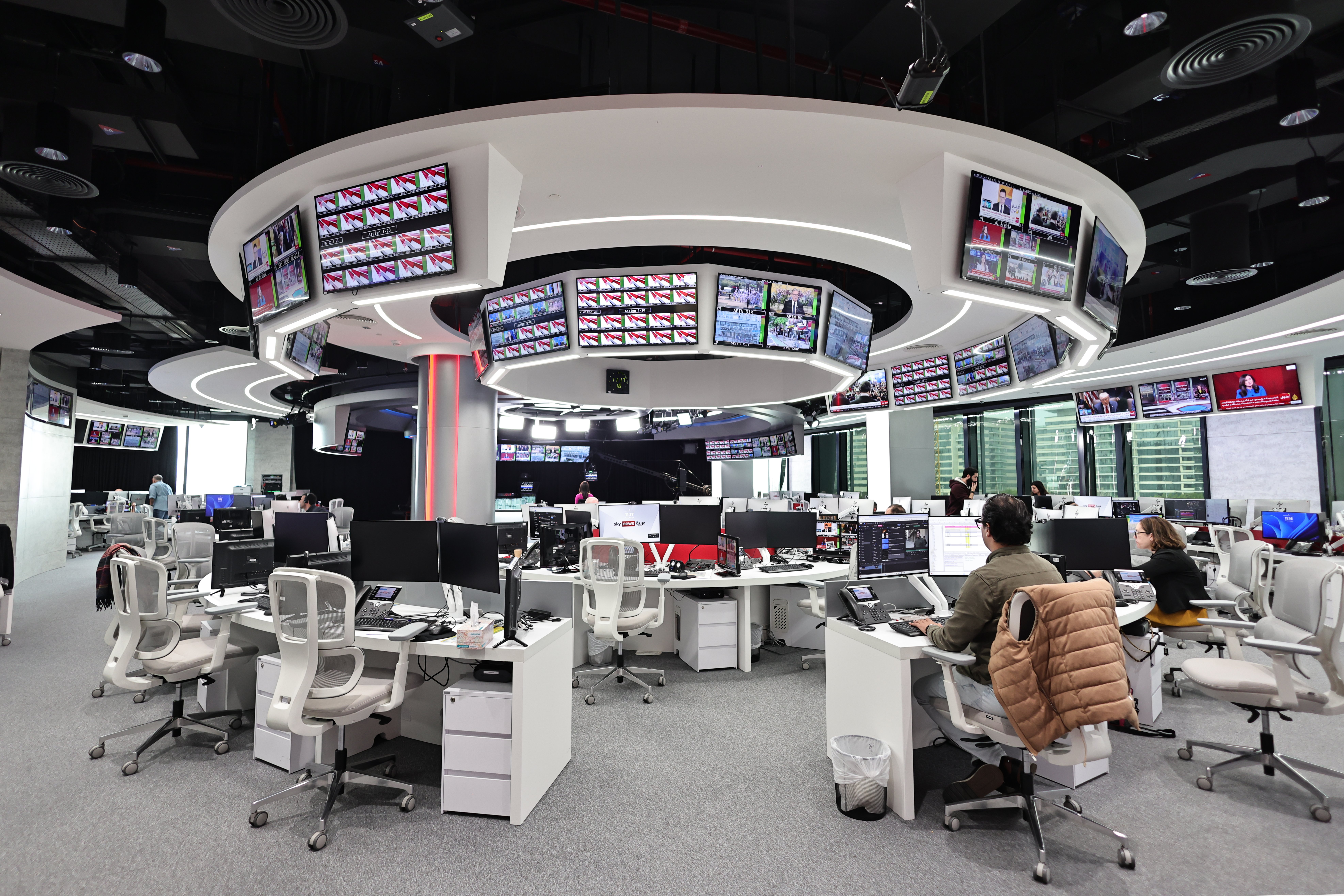 Moderne Nachrichtenredaktion mit mehreren Bildschirmen.