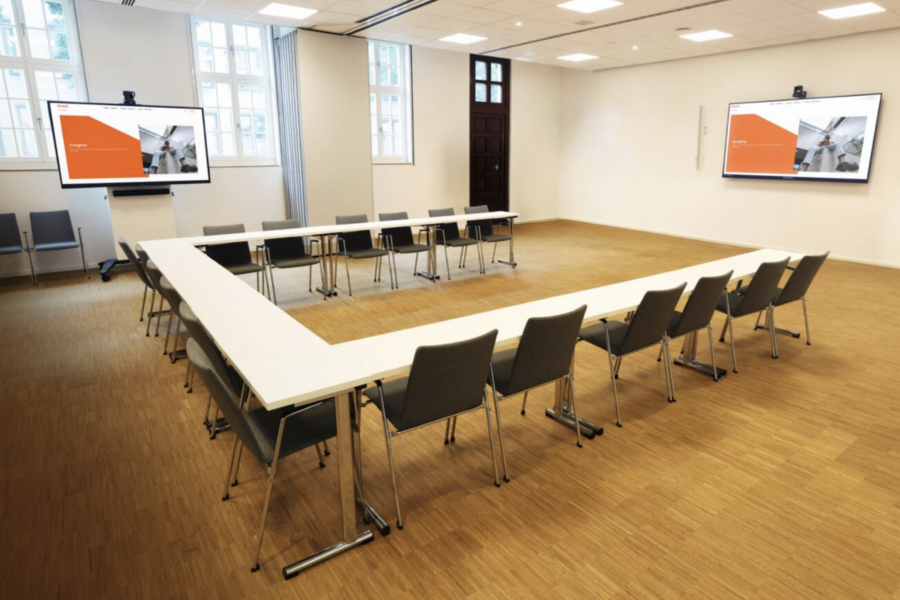 Modern meeting room setup with screens.