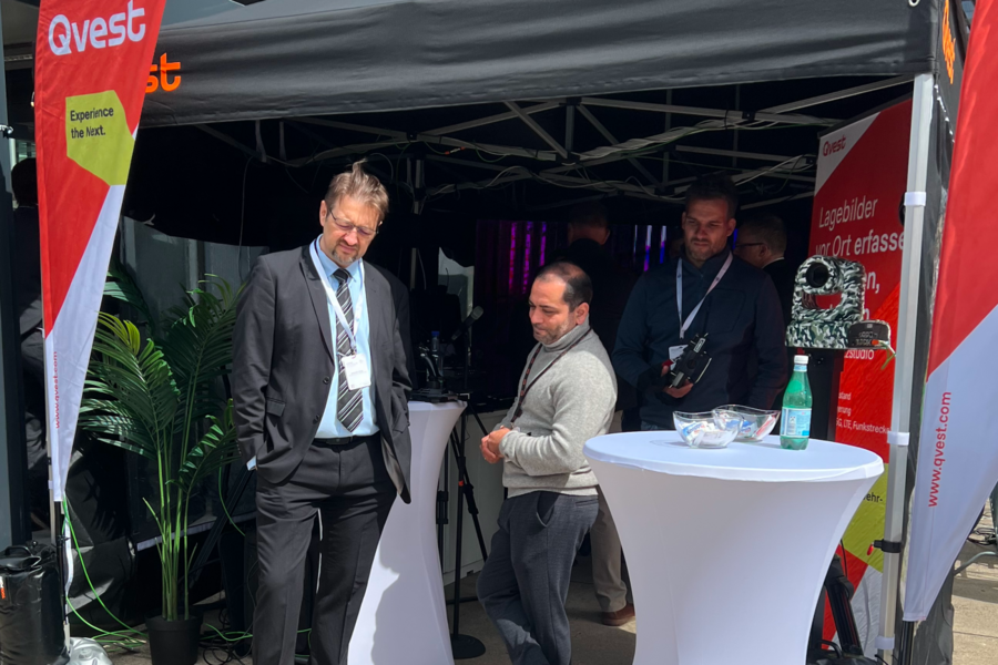 Menschen an einem temporären Eventstand.
