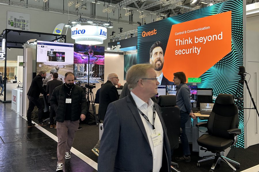 Messehalle mit Ständen und Besuchern.