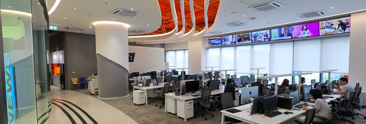 modern-newsroom-office.jpg Modern news office with active workstations and media content displays.