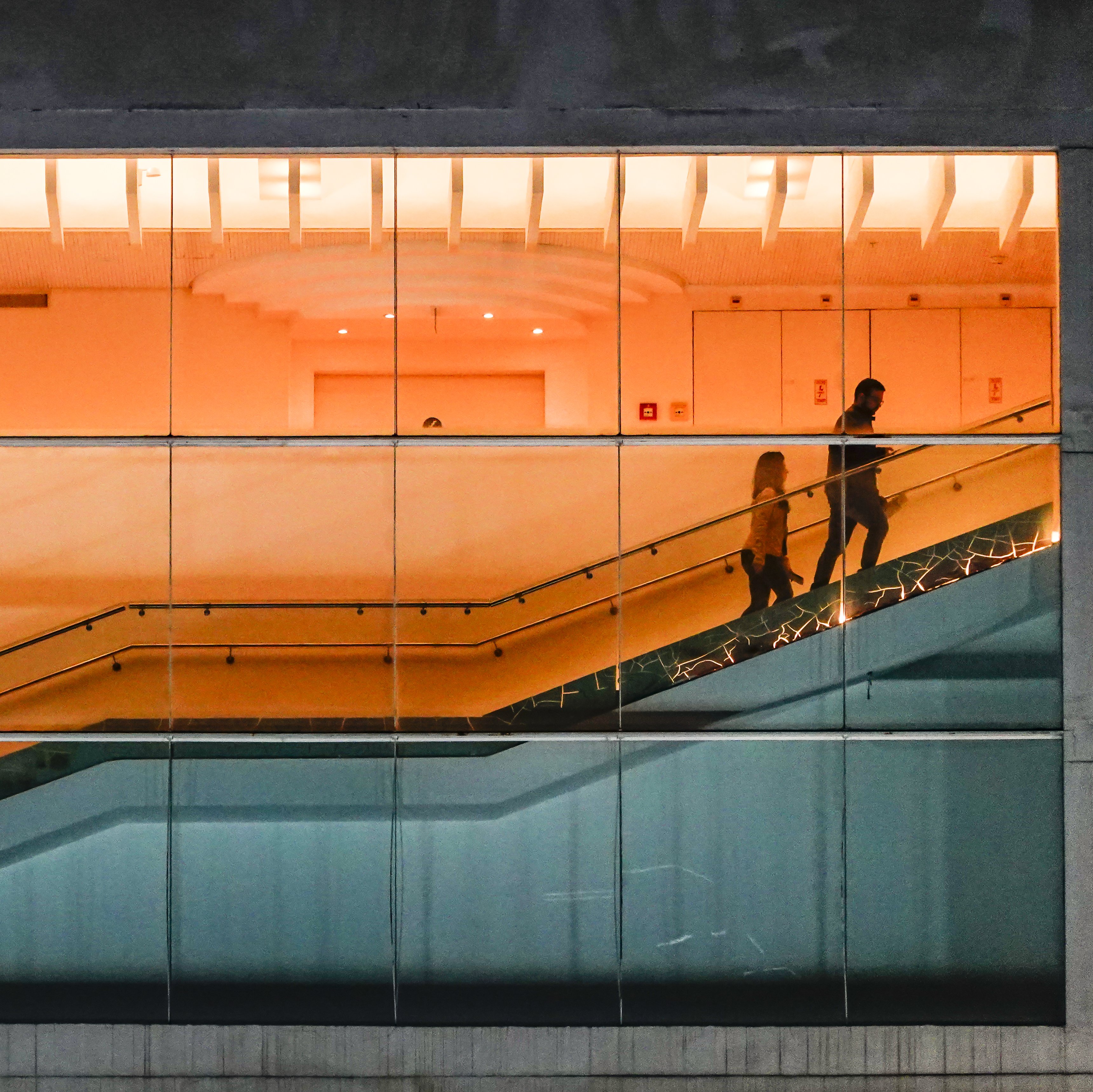 People walking on a staircase inside.