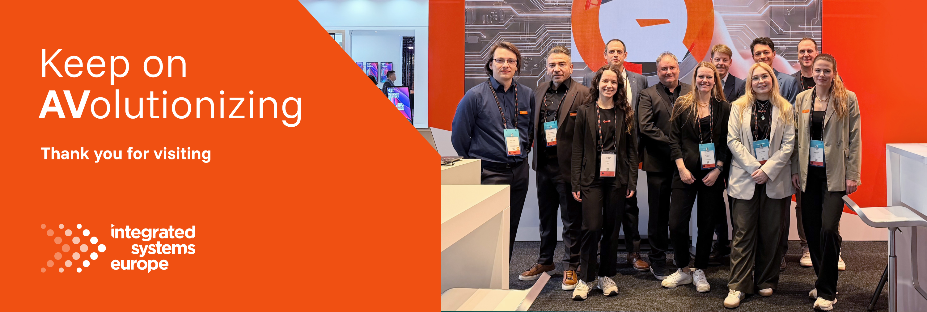 Trade show team at the Qvest booth with “Keep on AVolutionizing – Thank you for visiting”.