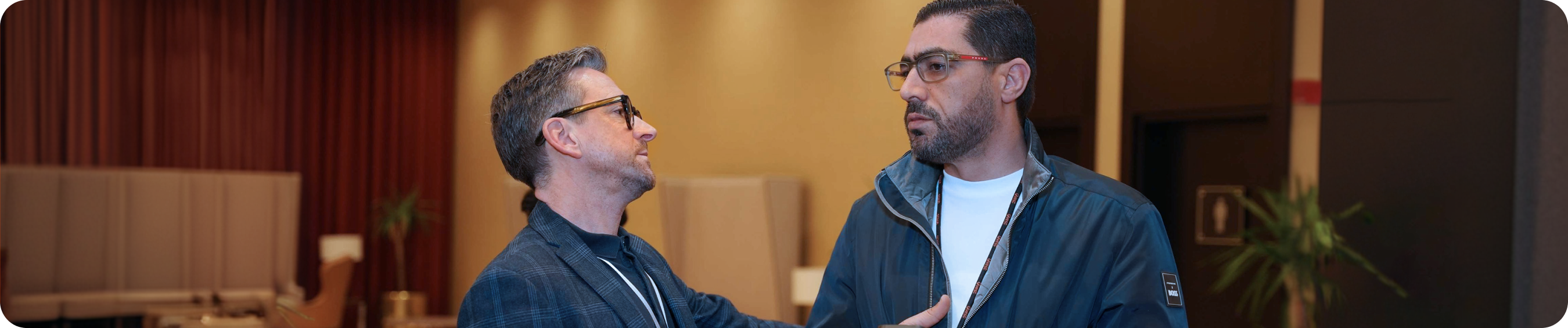 Two men talking indoors.